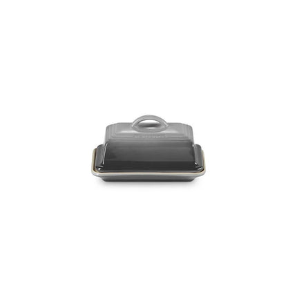 A black butter dish with a handle on top, sitting on a white background.