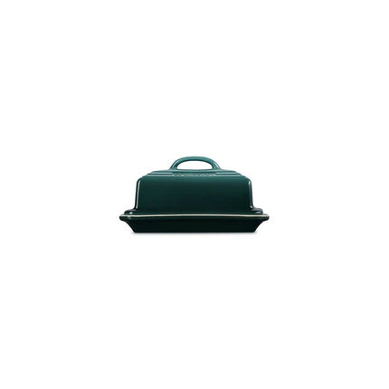 A dark green ceramic container with a handle, sitting on a white background.