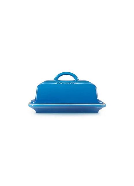 A blue ceramic butter dish with a handle on top.